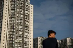 一名男子側著面,背景有住宅大廈。