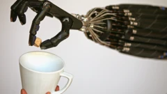 Uma mão robótica habilidosa colocando um cubo de açúcar em uma caneca.