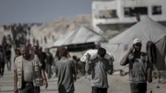 رجل فلسطيني يتسلم الطعام من نقطة توزيع مساعدات إنسانية في بيت لاهيا، شمال غزة، يوم الأحد 20 يوليو/تموز 2025. 