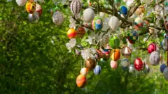 Óvos de páscoa decorados pendurados em uma macieira