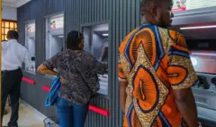 Wasu mutane suna cirar kuɗi daga na'urar ATM