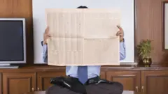 अखबार पढ़ता व्यक्ति