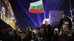 Protestujący macha flagą Bułgarii podczas demonstracji przed parlamentem podczas antyrządowego wiecu w Sofii