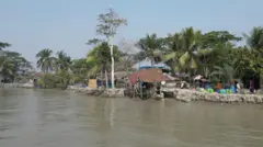 পশ্চিম চিলার এই গ্রামে পশুর নদীর কোল ঘেঁষে যে ভাঙা বাড়ির টিন দেখা যাচ্ছে সেটির বাকি অংশ নদীতে তলিয়ে গেছে। এখানেই অন্যের জমিতে ঘর বেঁধে বনজীবীরা থাকেন।