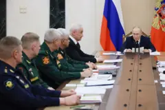 Vladimir Putin rodeado de sus generales en una mesa larga