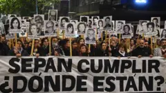 Cientos de personas marchan con carteles con imágenes de los desaparecidos en Uruguay. Al frente llevan una pancarta que dice "Sepán Cumplir. ¿Dónde están?"