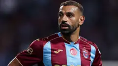 bordo mavi formalı arap futbolcu şaşkınlık içinde kendi sağına bir yere bakıyor.