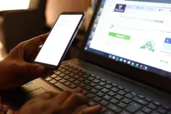 Une femme avec un téléphone et un ordinateur connectés à Internet