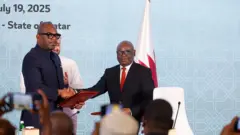 Sumbu Sita Mambu (ibumoso), intumwa nkuru ya Perezida wa DRC Félix Tshisekedi, n'umunyamabanga nshingwabikorwa wa M23, Benjamin Mbonimpa basuhuzanya nyuma yo gusinya amahame yo kurangiza intambara. Aha ni i Doha, mu murwa mukuru wa Qatar, ku wa gatandatu ku itariki ya 19 Nyakanga (7) mu mwaka wa 2025. 