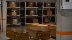 File photo of a stack of coffins in a mortuary