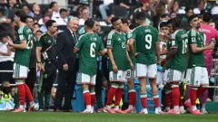 Jogadores do México bebem perto da linha lateral durante a pausa para hidratação na partida de abertura da Copa do Mundo de 2026 contra a África do Sul