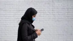 زن جوان با موبایل در تهران