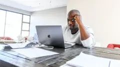 Un homme travaille depuis sa maison à Ruimsig pendant le confinement le 14 mai 2020 à Johannesburg, en Afrique du Sud.