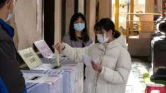 一名台湾年轻女性选举时在投票所投票。