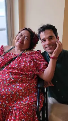 Dona Onete acaricia rosto de repórter enquanto posam para foto