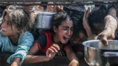 Niños piden comida en Gaza.