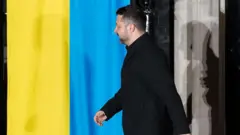 Зеленський йде на фоні українського прапору 