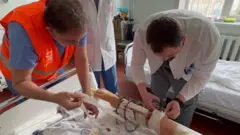 Dr Monzer Yazji and another doctor dressing a injured leg
