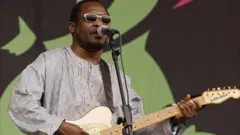 Amadou Bagayoko joue de la guitare sur scène