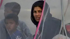 Displaced Afghans sit in a tent at a makeshift IDP camp in Share-e-Naw park in Kabul