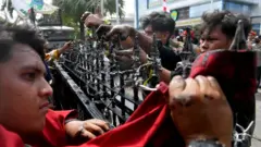 Masa aksi berusaha melepas kawat berduri saat unjuk rasa di depan kantor Gubernur Kalimantan Timur, Samarinda, Kalimantan Timur, Selasa (21/4/2026).