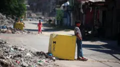 فتى يستند على مربع اسمنتي أصفر اللون يحدد الخط الأصفر في غزة