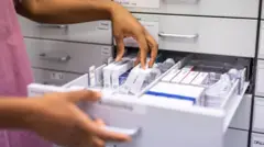 Eczanede ilaçları kontrol eden bir görevli