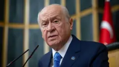 Devlet Bahçeli yana bakarak meclis kürsüsünde konuşuyor