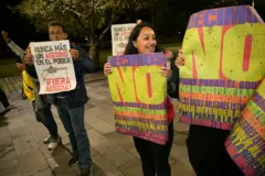 Gente manifestándose con carteles que dicen "no".