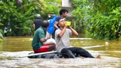 People navigate floodwaters on a makeshift raft as heavy rains from Cyclone ''Ditwah'' sweep through Colombo, Sri Lanka, on 29 November 2025.