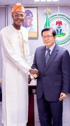 Adeyemi Adeniyi and an Asian man shake hands
