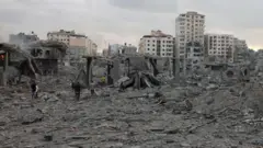 Palestinians inspect the destruction following Israeli airstrikes on Gaza City's al-Rimal district, early on October 10, 2023