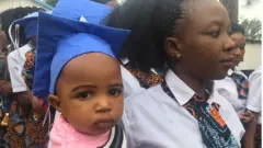 Mzazi akiwa na mtoto wake siku ya kufuzu kwa mahafali