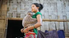 পার্বত্য জেলা বান্দরবানে বাচ্চা কোলে এক উপজাতীয় নারী।
