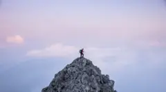 Uma pessoa caminhando até o topo de uma montanha