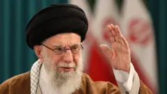 Ali Khamenei está com uma das mãos levantadas, saudando pessoas
