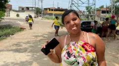 Mulher sorrindo em rua, com outras pessoas atrás