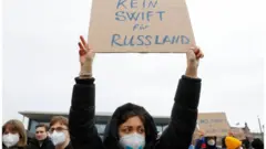 Demonstrators carry placcard