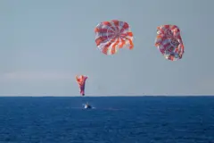 নভোচারীদের বহনকারী ক্যাপসুলটি প্রশান্ত মহাসাগরে অবতরণের দৃশ্য