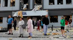 Kyiv、サインのあるBritish Councilsのある破損した建物の背景に反対する人々