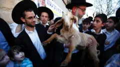 A member of the Temple Institute holds a one-year-old flawless goat in an enactment of the preparation for the Passover sacrifice