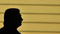 Foto da sombra do rosto de Bolsonaro de perfil.