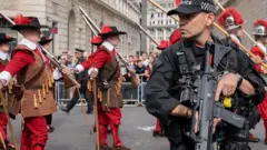 The Company of Pikemen and Musketeers march past armed police and the Bank of England, London, 9 September 2022
