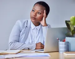 femme anxieuse assise devant son bureau