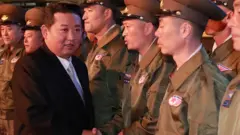 North Korea's leader Kim Jong Un greets military personnel at the Defence Development Exhibition, in Pyongyang, North Korea, in this undated photo released on 12 October 2021