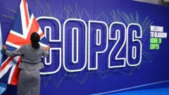 Umugore ufashe ku ibendera ry'Ubwongereza muri COP26