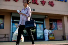 2025年4月10日，加州西敏市的“东方超级市场”外，有一名女性顾客正挽着购物袋。