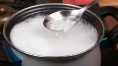 Arroz em recipiente com água fervendo