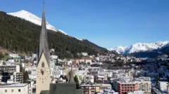 Vista da igreja de São João e da cidade de Davos antes da reunião anual do Fórum Econômico Mundial. Há uma leve camada de neve sobre a cidade e montanhas podem ser vistas ao fundo.