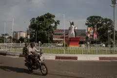 Une place de la capitale guinéenne, un monument représentant une femme habillée en robe blanche tenant une colombe d'une main droite